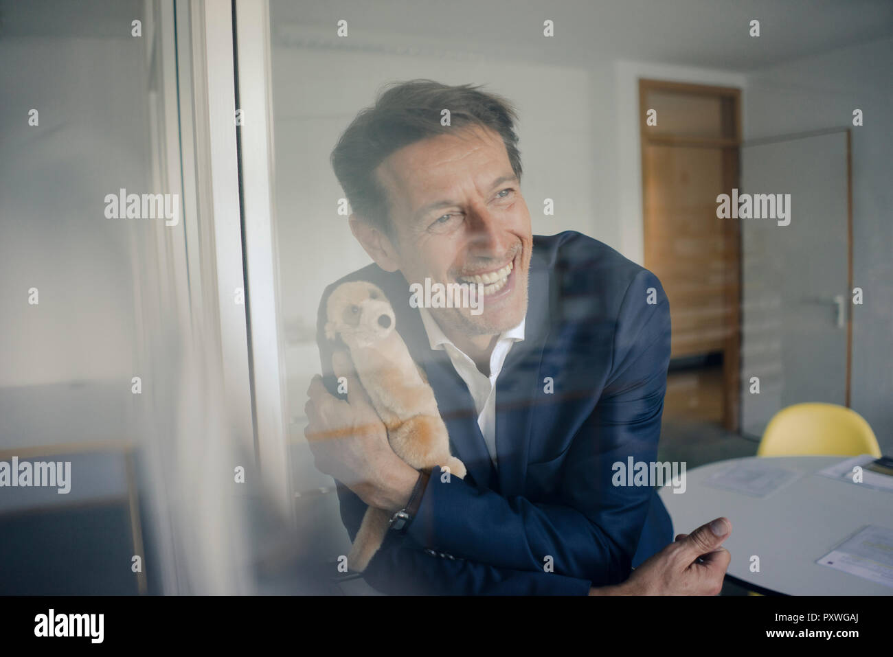 Successful businessman holding cuddly toy Stock Photo