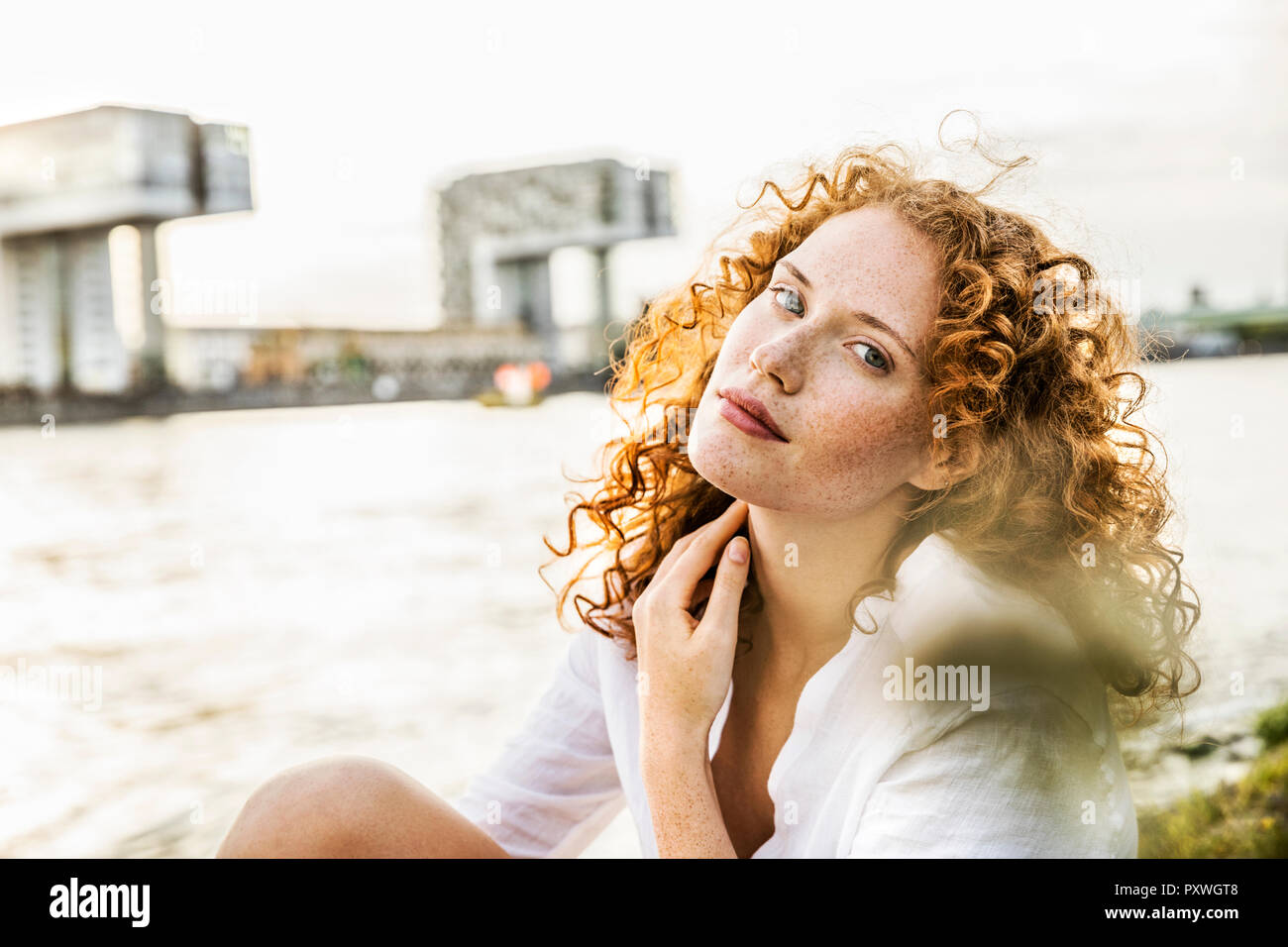 Germany, Cologne, portrait of freckled young woman with curly red hair Stock Photo