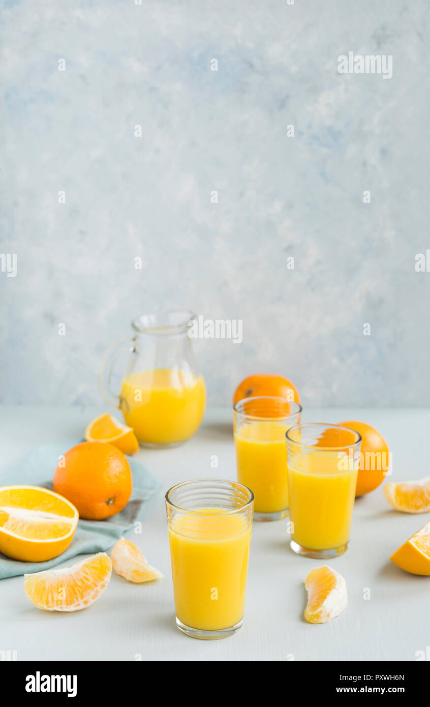 Glasses of freshly squeezed orange juice and oranges Stock Photo