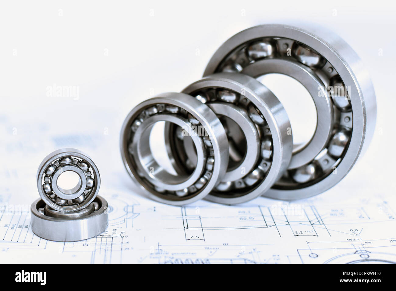 Quality control in modern mechanical engineering technical drawing and ball bearings on white