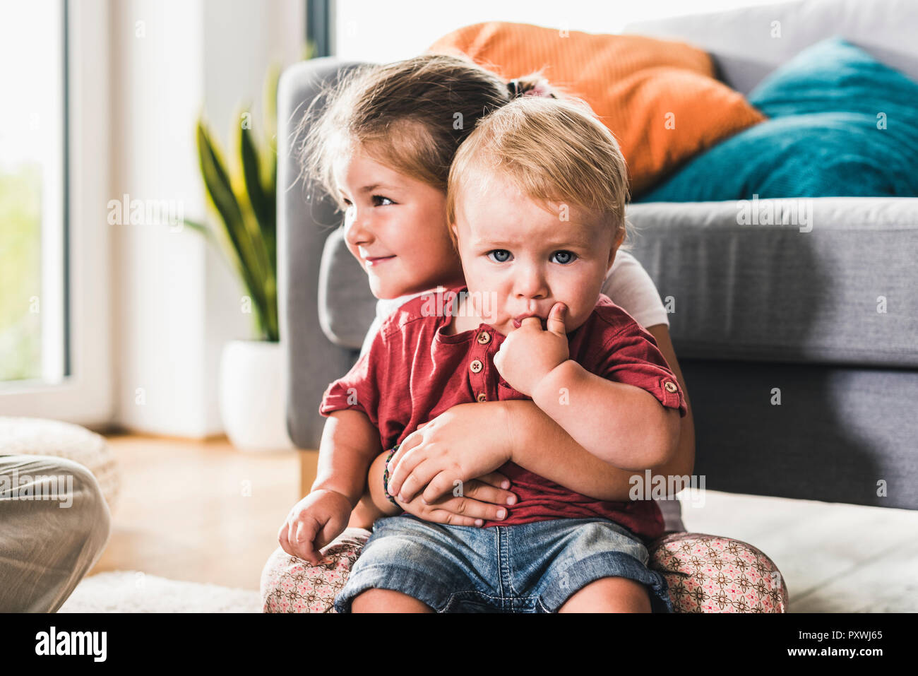 Brother and sister at home in living room Stock Photo