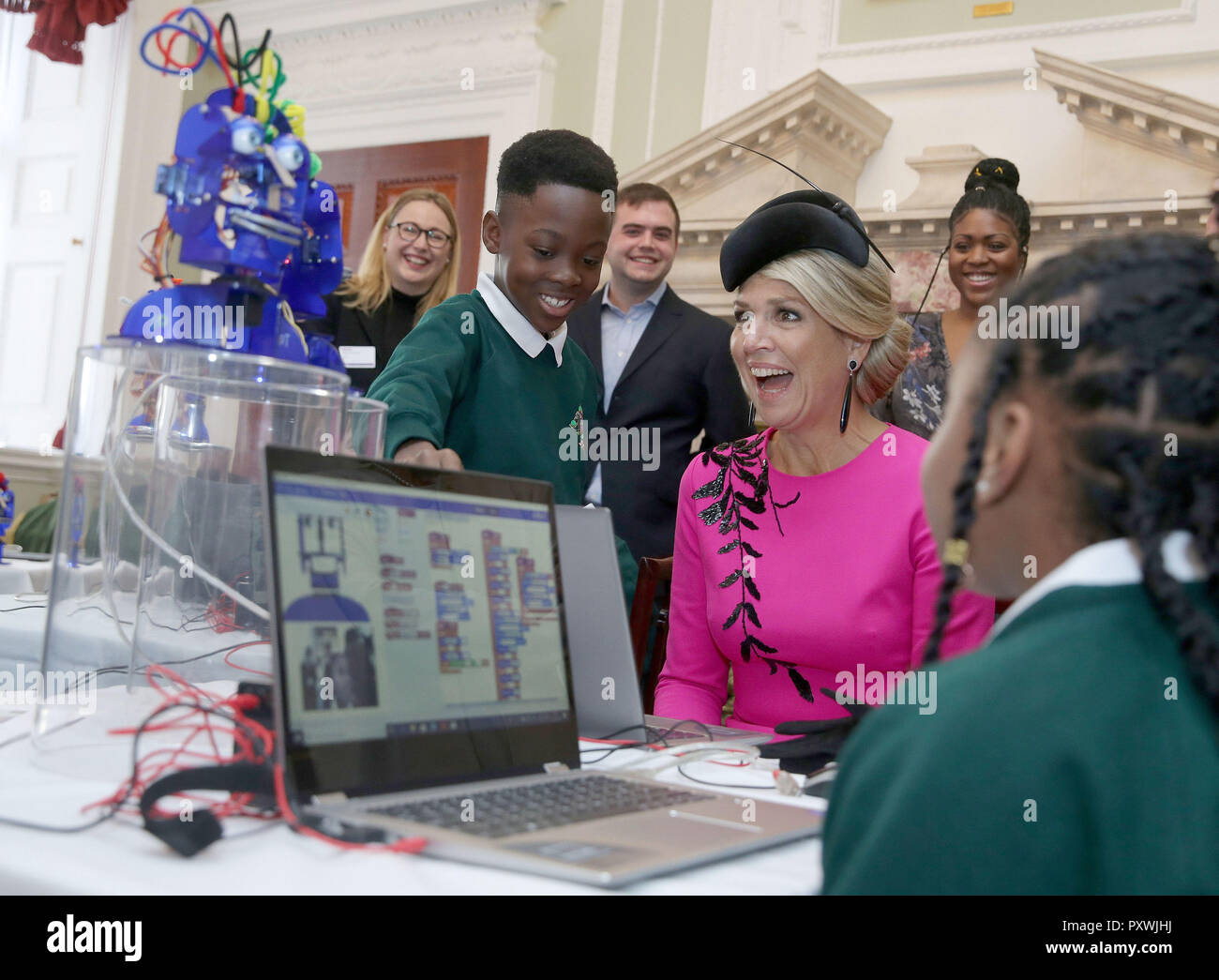 Queen Maxima of the Netherlands reacts as she interacts with school children as they work on the Ohbot, an educational robotics system, at the UK-Netherlands Innovation Showcase at Mansion House in London on the second day of her State Visit to the UK. Stock Photo