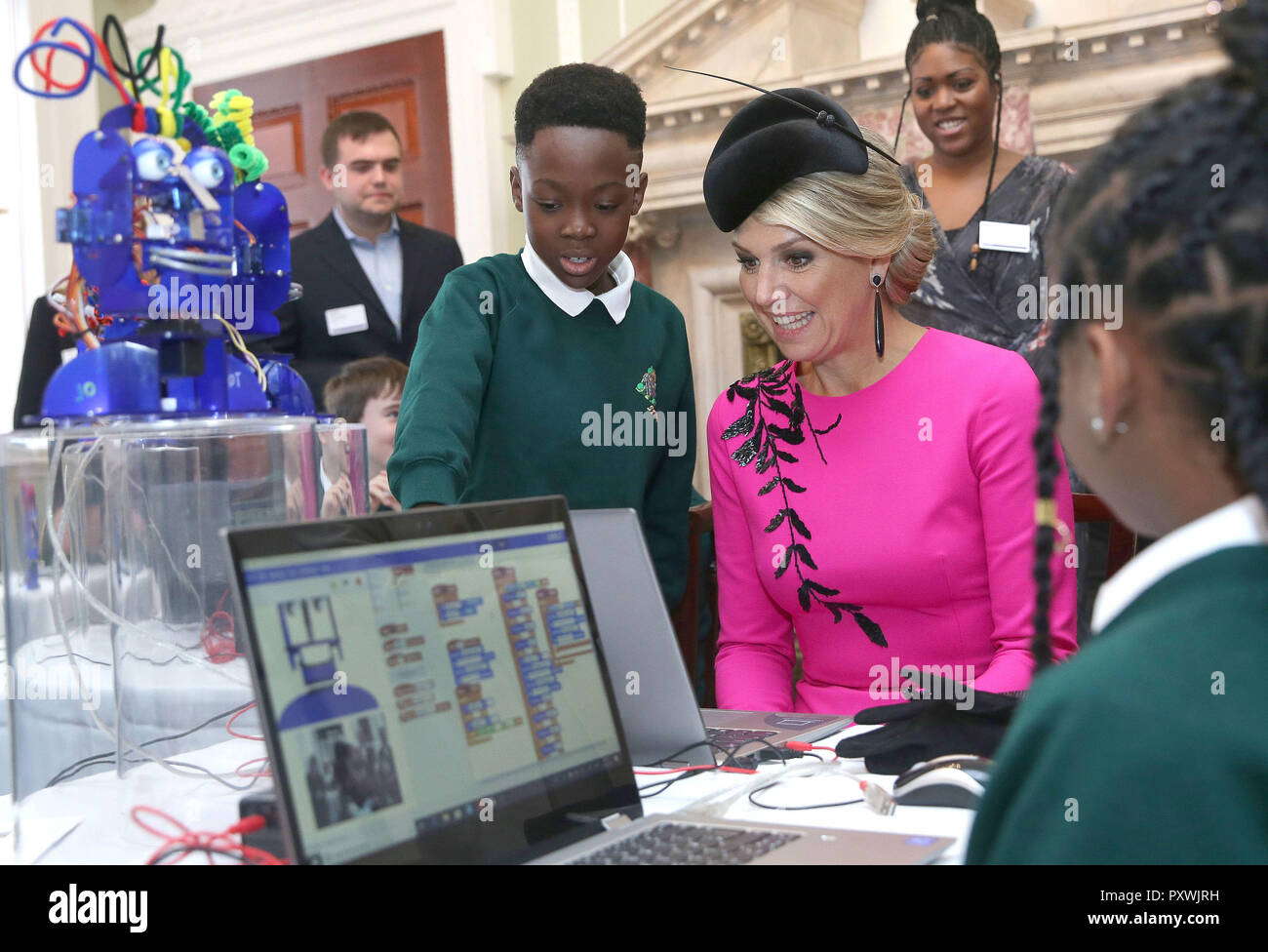 Queen Maxima of the Netherlands reacts as she interacts with school children as they work on the Ohbot, an educational robotics system, at the UK-Netherlands Innovation Showcase at Mansion House in London on the second day of her State Visit to the UK. Stock Photo
