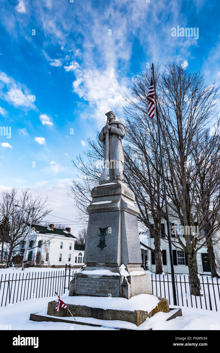 Marble monument to soldiers who fought in the Civil War covered in snow, with American flag. Stock Photo