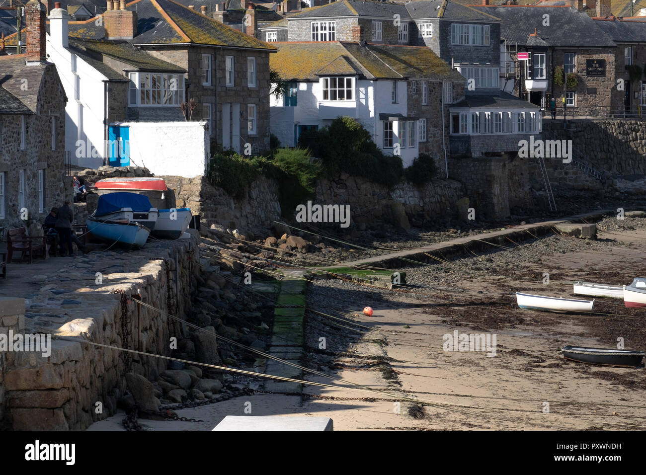 Mousehole, traditional Cornish fishing village at low tide with a view