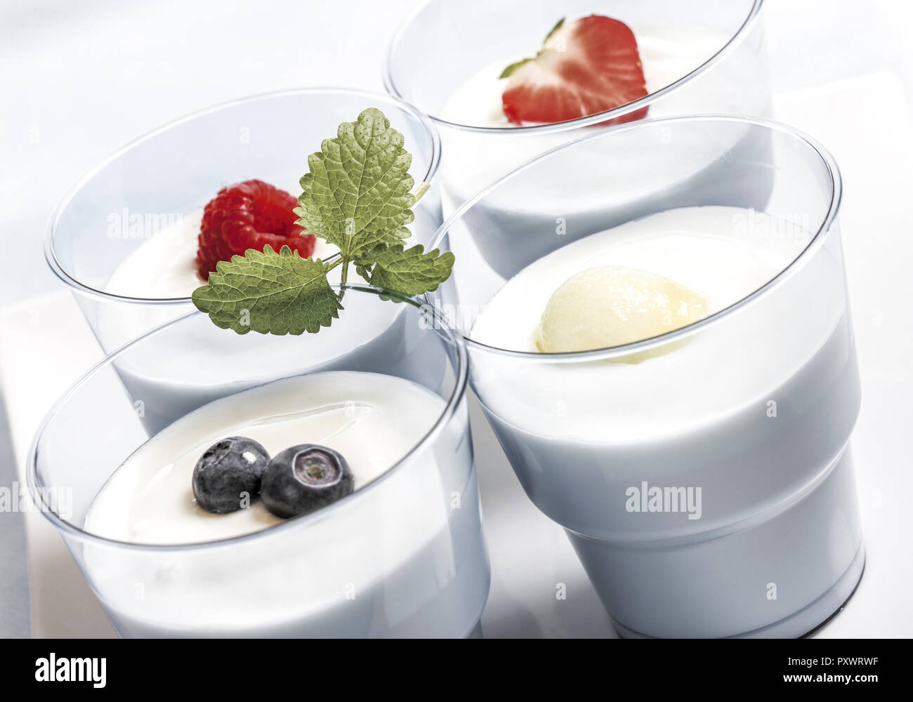 Vier Glaeser mit Joghurt und frischem Obst Stock Photo