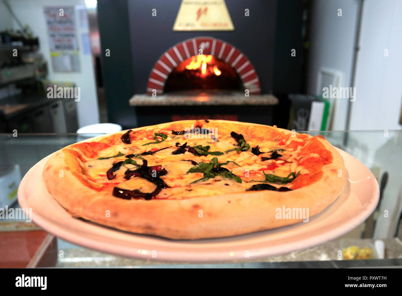 ham, mushrooms, black olives & artichokes Pizza, cooked in a traditional wood fired pizza oven Stock Photo