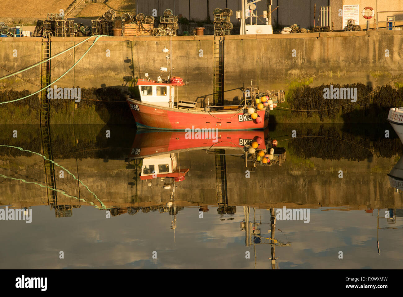 Reflection of a fishing boat in Seahouses harbour, Northumberland, England Stock Photo
