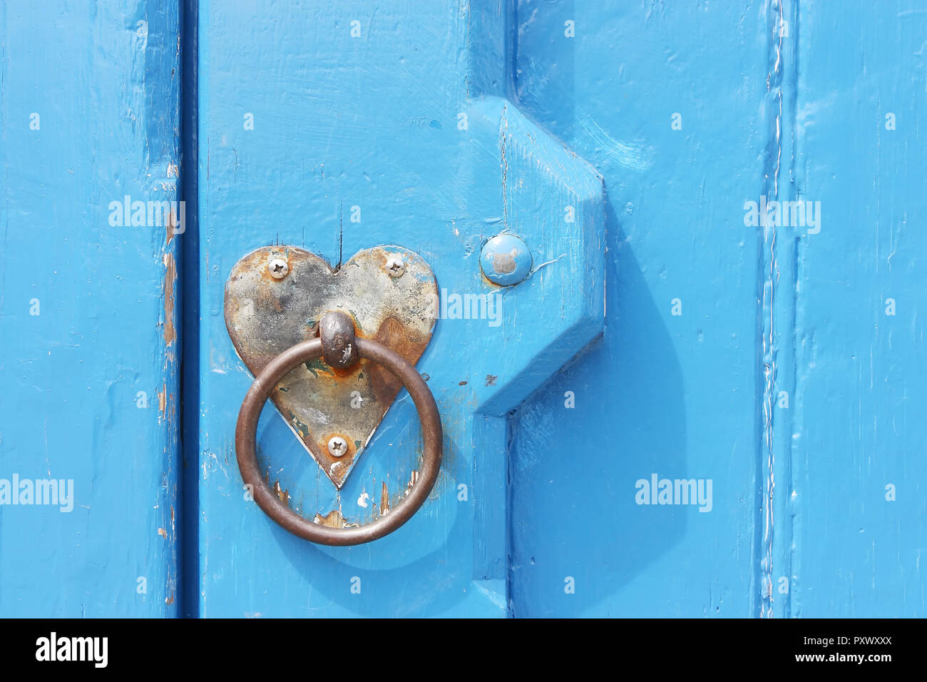 Detail of old blue door with heart formed backplate for use as a valentine card or template with copy space Stock Photo