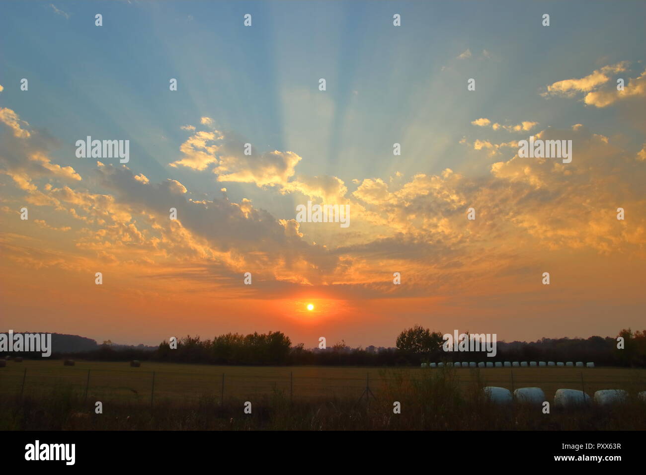 Sun rays over sky at sunset Stock Photo