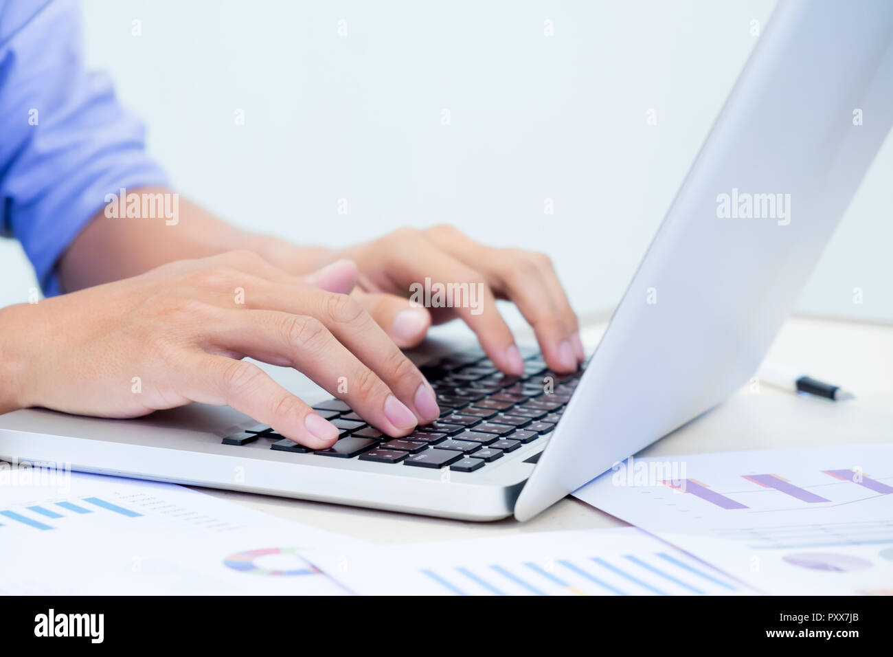 Man's hands typing on laptop keyboard Stock Photo