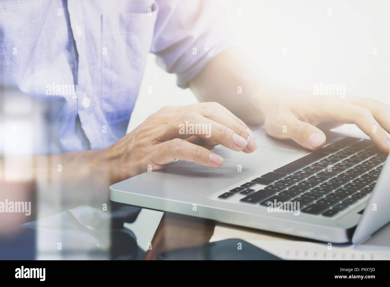 Man's hands typing on laptop keyboard Stock Photo