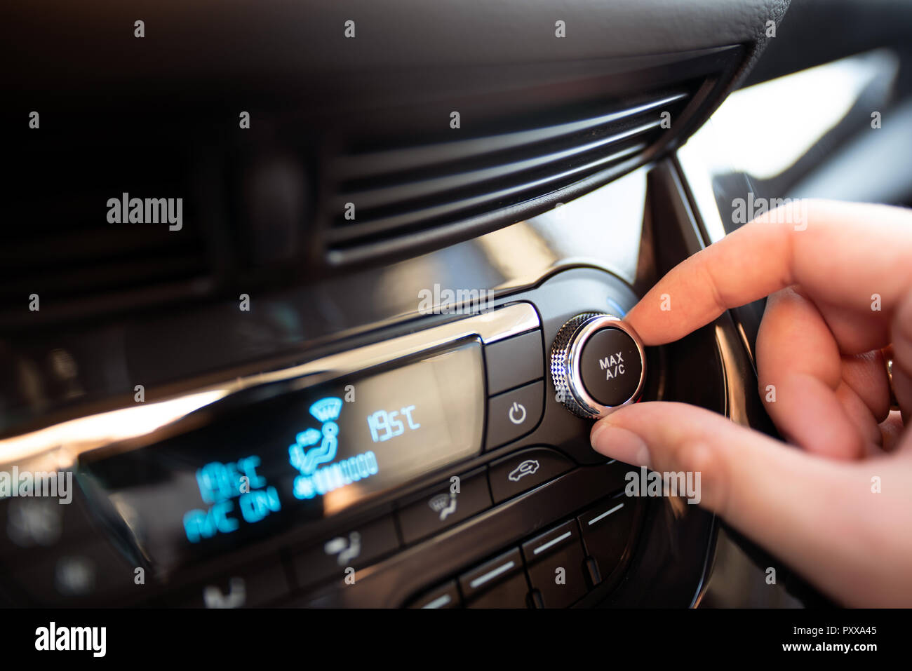 Man turning on car air conditioning system. Air conditioning button