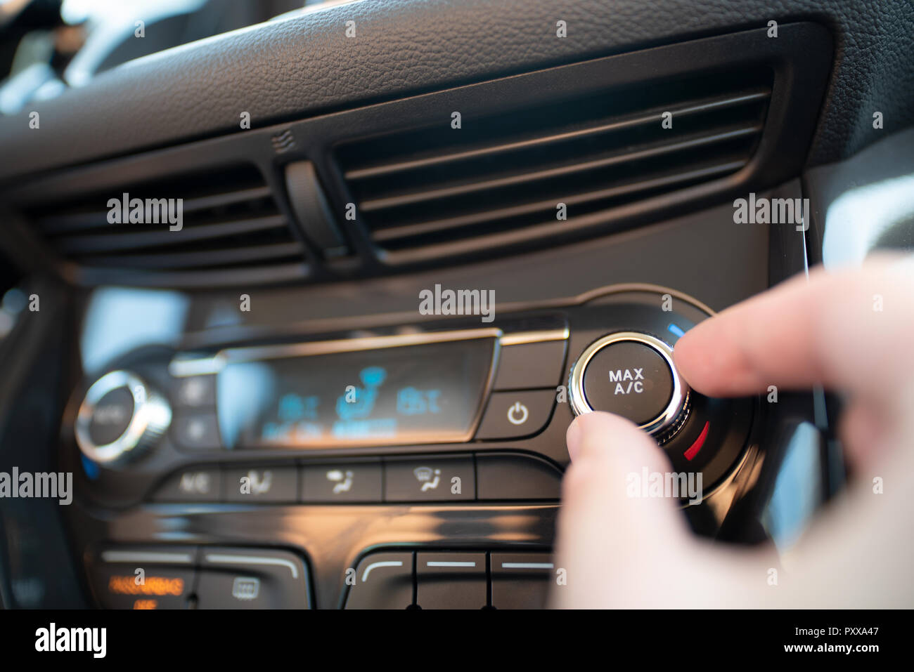 Man turning on car air conditioning system. Air conditioning button