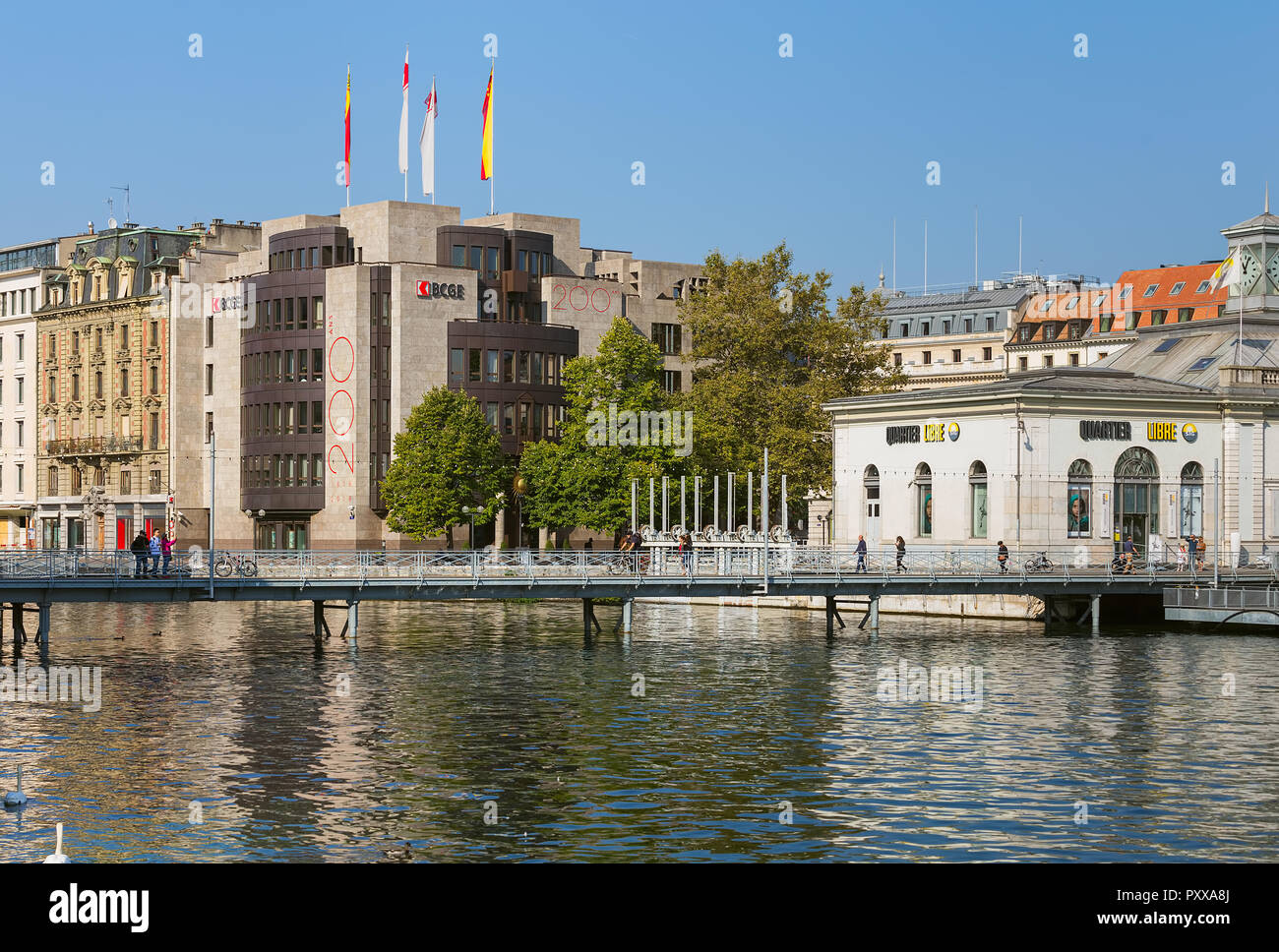 Geneva, Switzerland - September 24, 2016: people on a bridge over the Rhone river, building of the Cantonal Bank of Geneva in the background. Geneva i Stock Photo