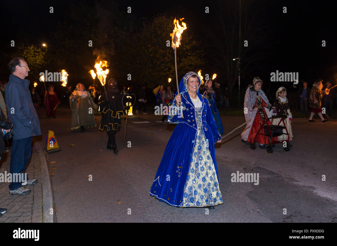 Woman leading a group of people walking in a procession at the yearly Guy Fakes / Bonfire night parade in Littlehampton, West Sussex, UK. Stock Photo