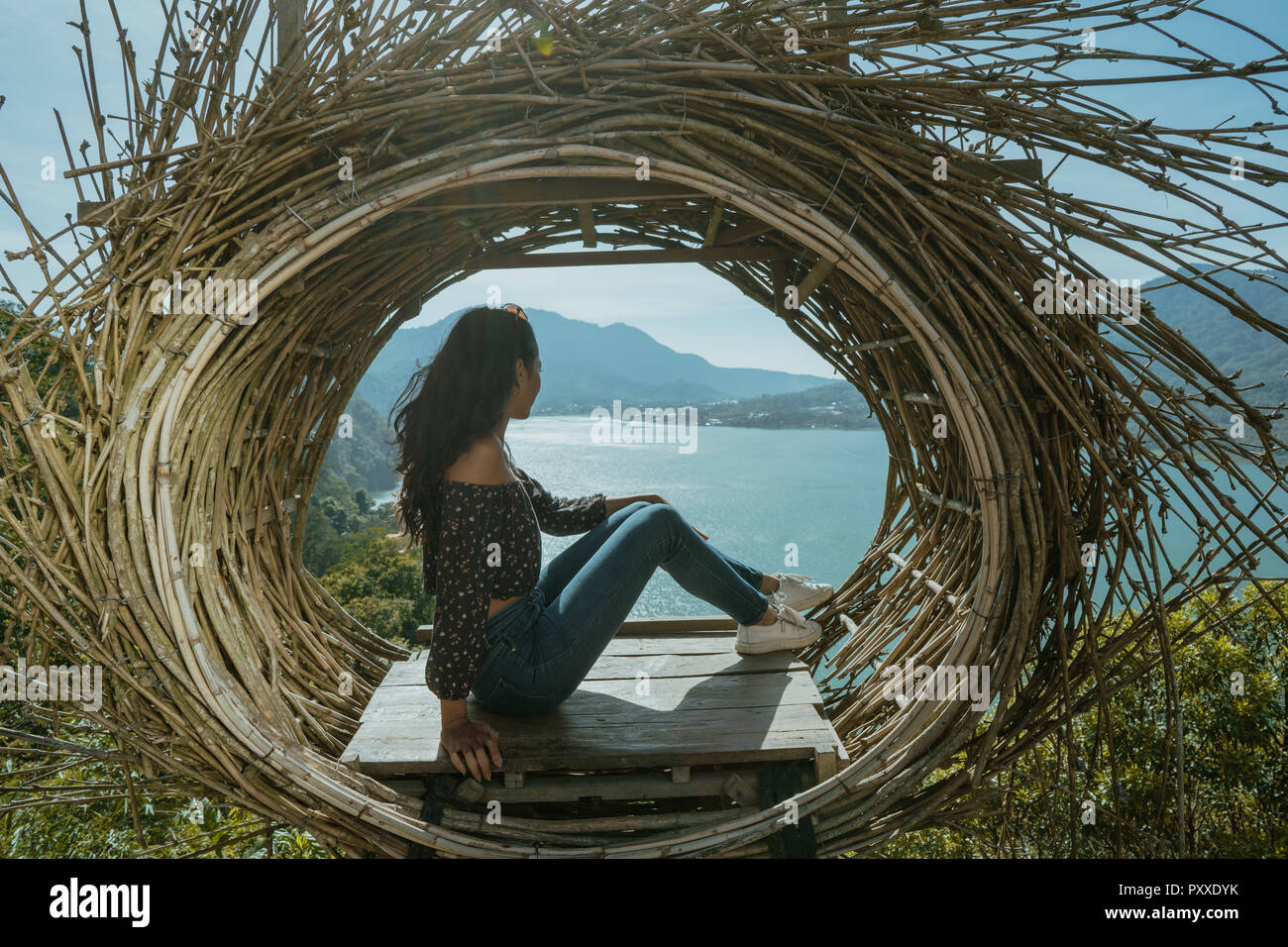 woman sitting on a wood on top of the mountain Stock Photo