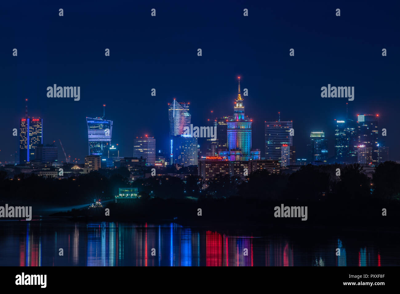 Warsaw / Poland - October 7.2018. Night view on the downtown city buildings with colorful lights reflection in the river. Stock Photo