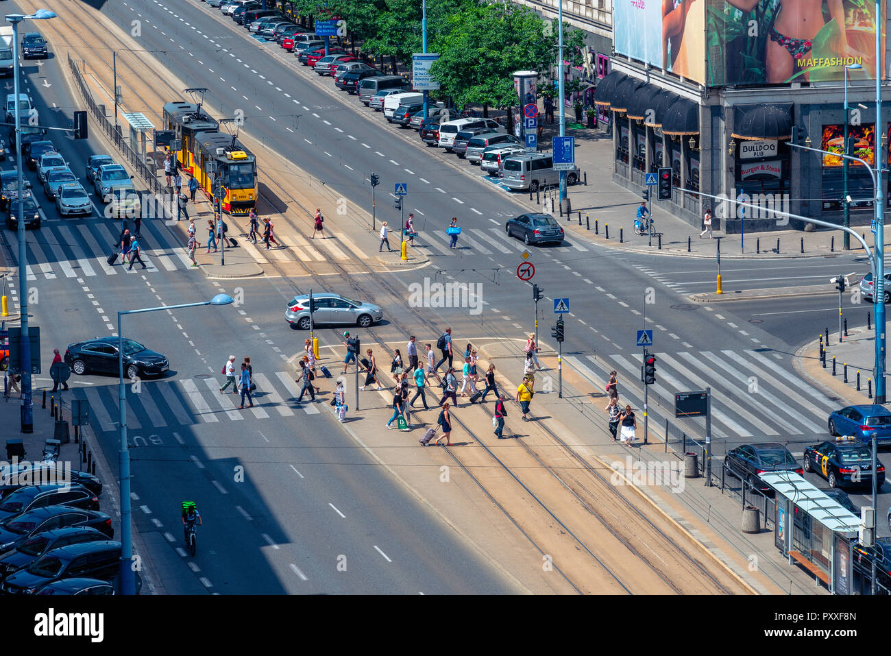 Warsaw / Poland - June.17.2018. View from the top on the city cross road with people crossing the street and traffic. Sunny day. Stock Photo