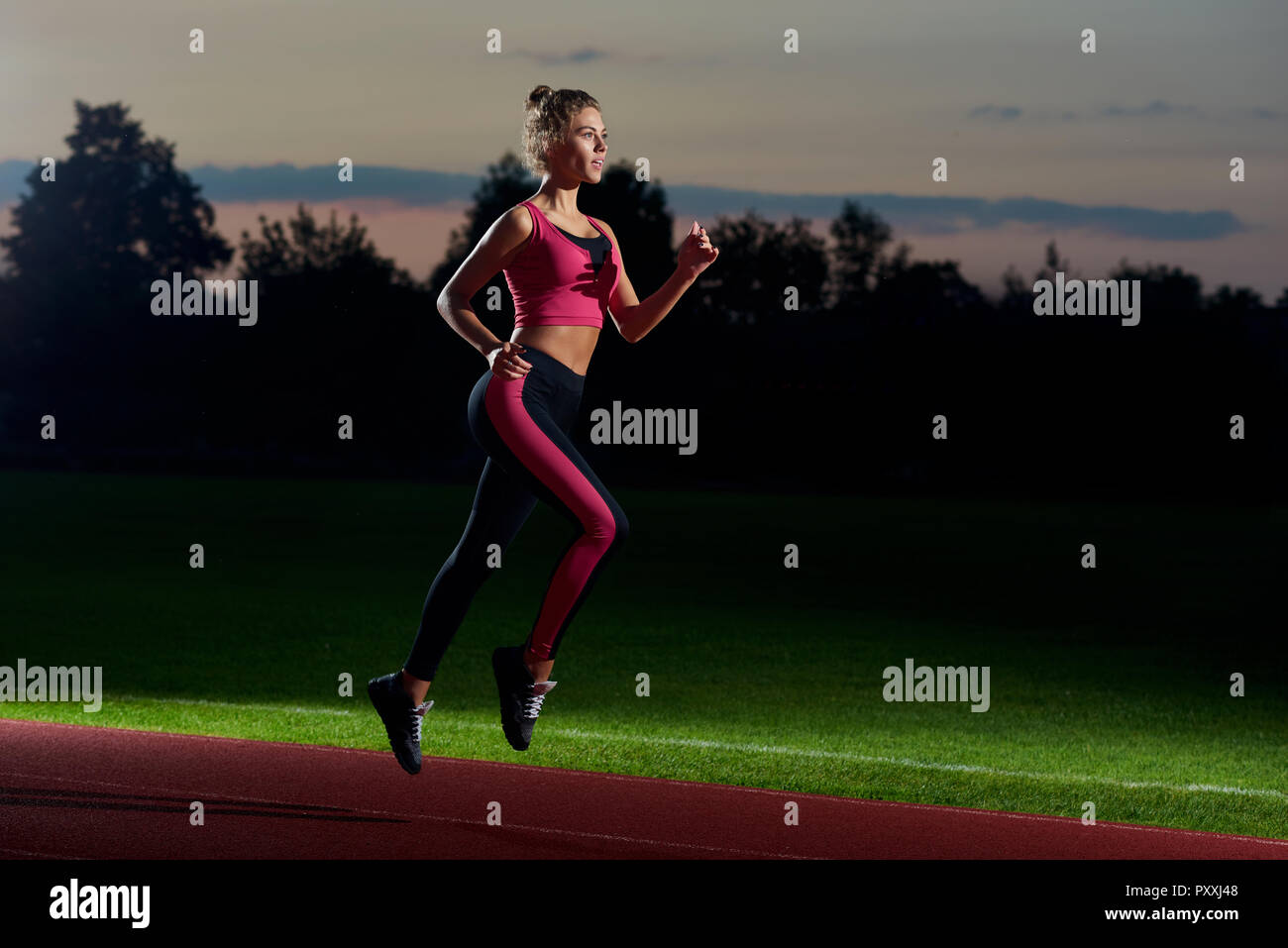 Side view of pretty and athletic girl in stylish black and pink sport