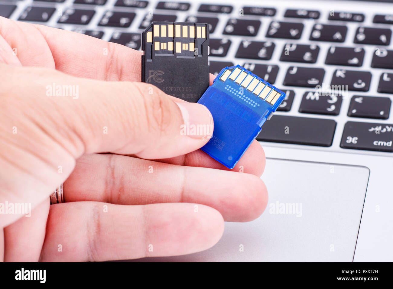Fast SD memory card holding by fingers Stock Photo