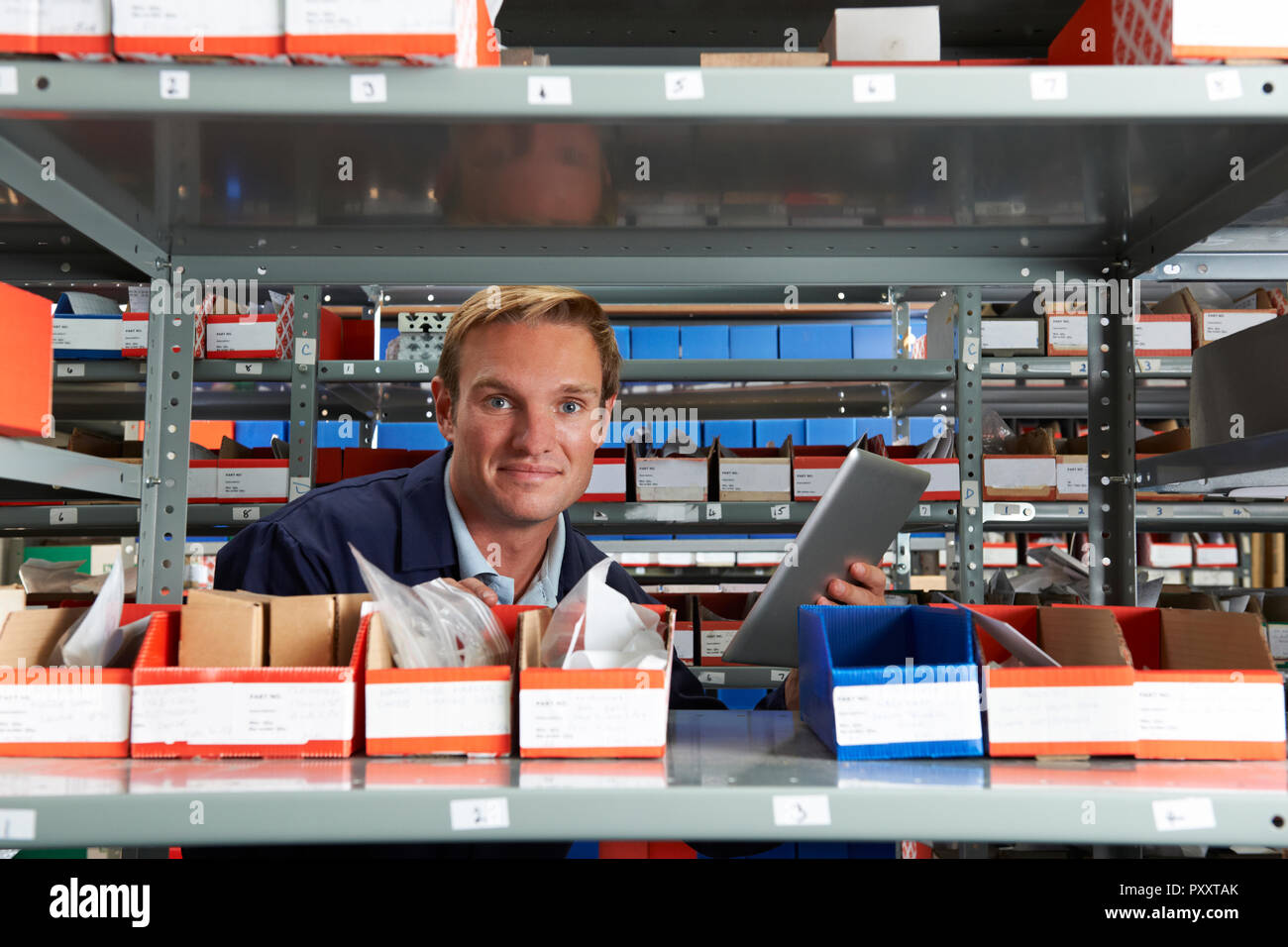 Portrait Of Factory Worker Using Digital Tablet In Store Room Stock Photo