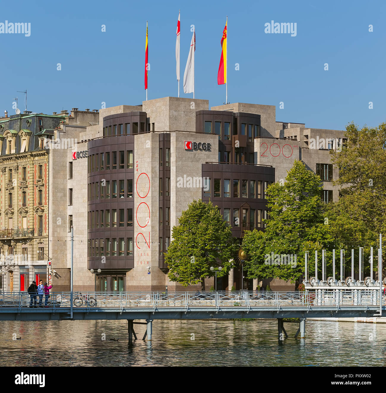 Geneva, Switzerland - September 24, 2016: people on a bridge over the Rhone river, building of the Cantonal Bank of Geneva in the background. Geneva i Stock Photo