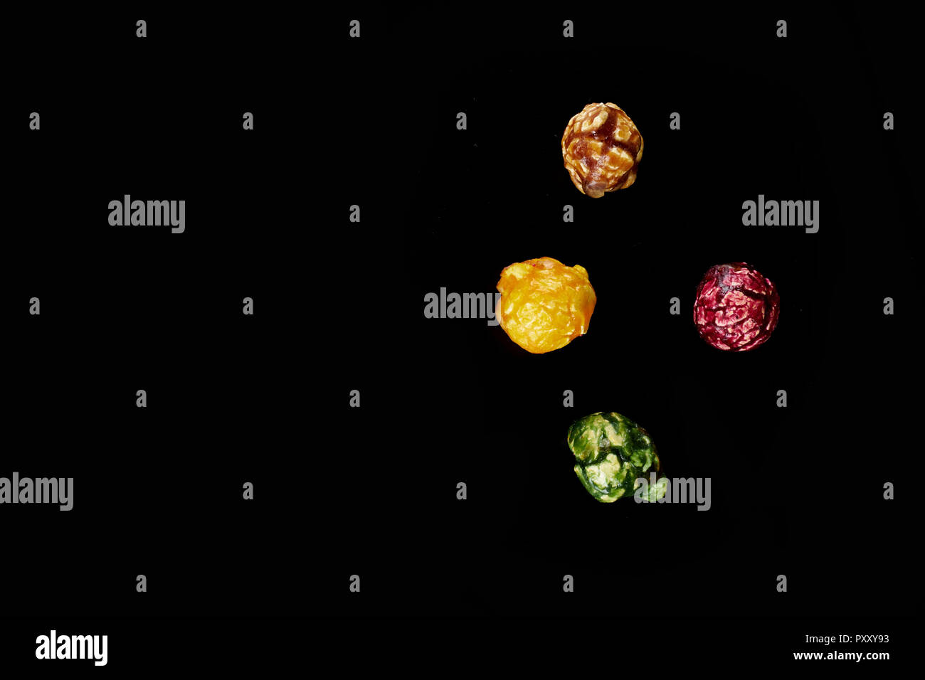 multicolored caramel popcorn on a black background. Stock Photo