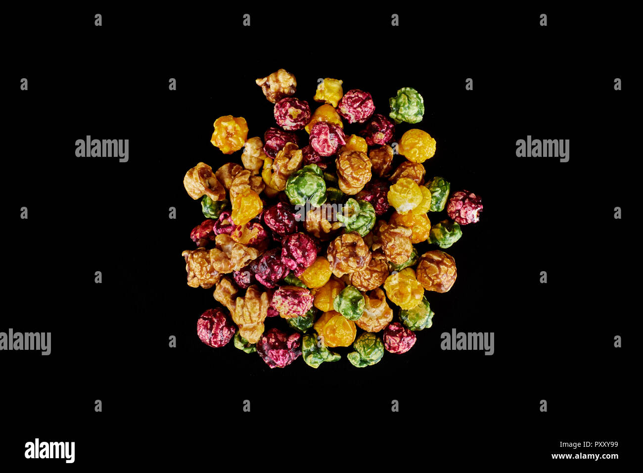 multicolored caramel popcorn on a black background. Stock Photo