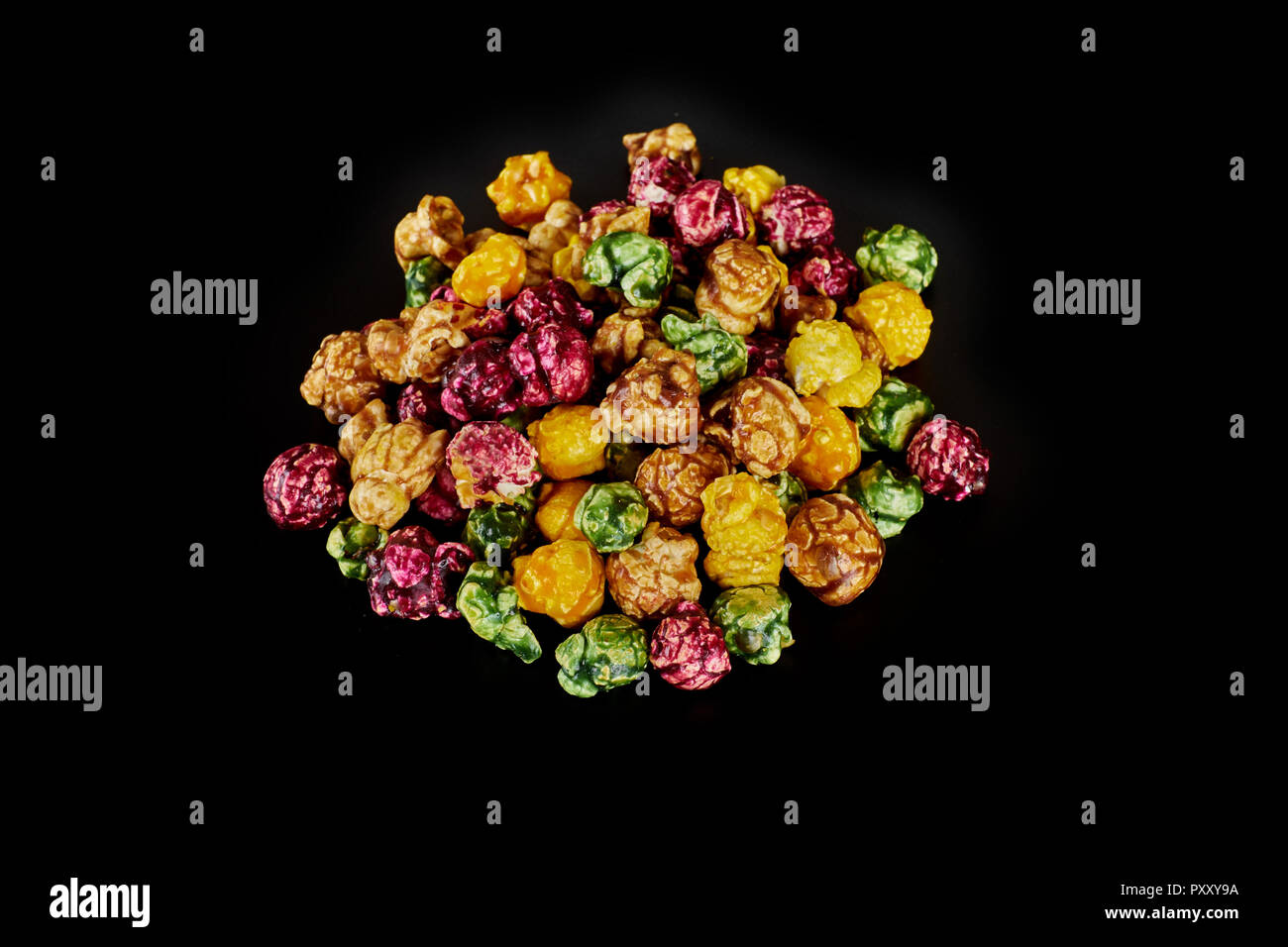 multicolored caramel popcorn on a black background. Stock Photo