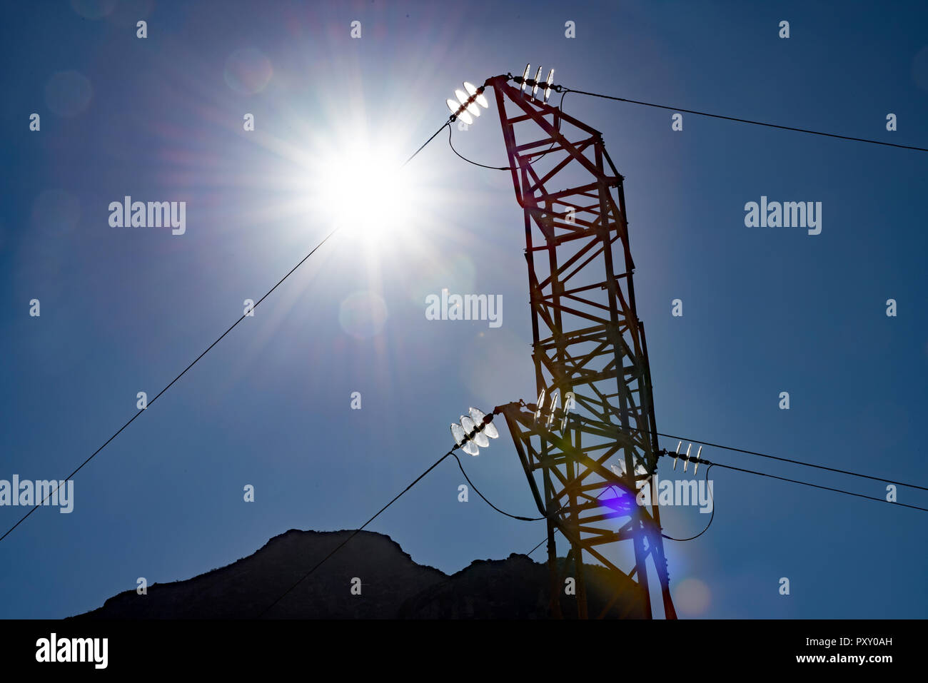 High Voltage pylons against a sunny blue sky Stock Photo - Alamy