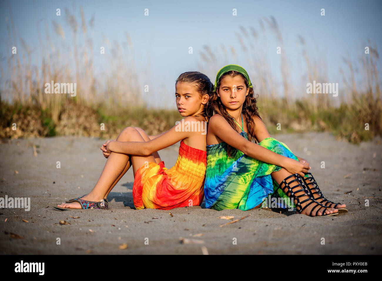 Two Beautiful young girls sitting on the beach Stock Photo - Alamy
