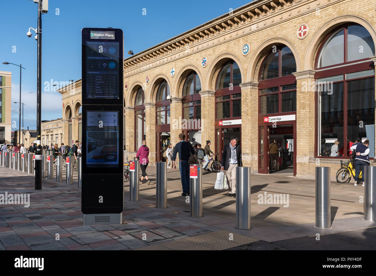 People walking past Cambridge railway station entrance with new electronic information board, Cambridge, UK Stock Photo