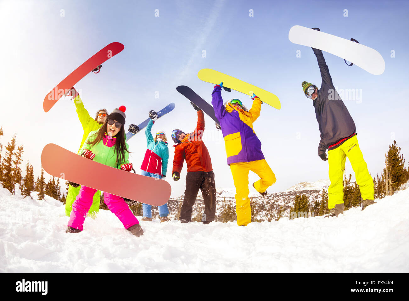 Big group of friends snowboarders are having fun with snowboards on mountain top of ski resort Stock Photo