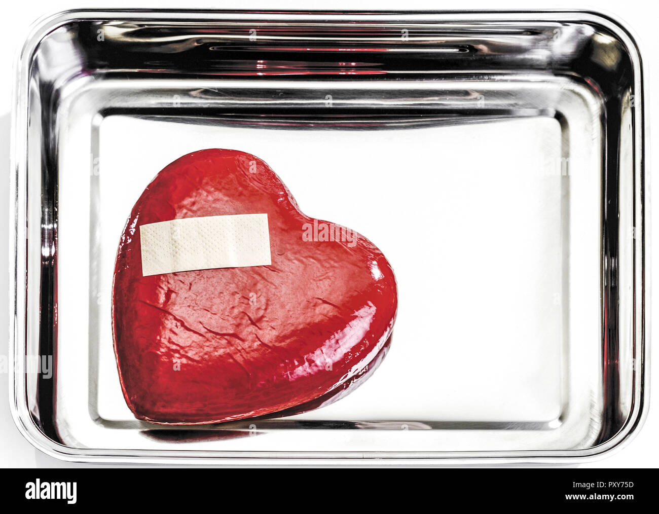 Rotes Herz mit Pflaster liegt in Metallschale Stock Photo