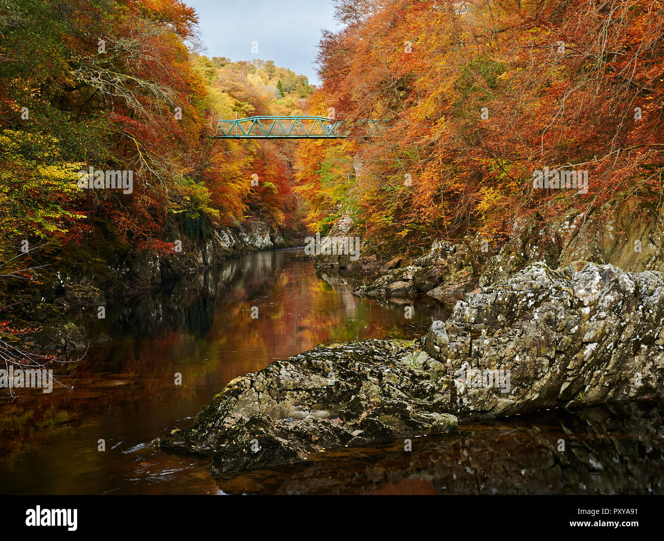 The green footbridge over the River Gary between Pitlochry and Killiecrankie, Perthshire, Scotland in autumn. Stock Photo