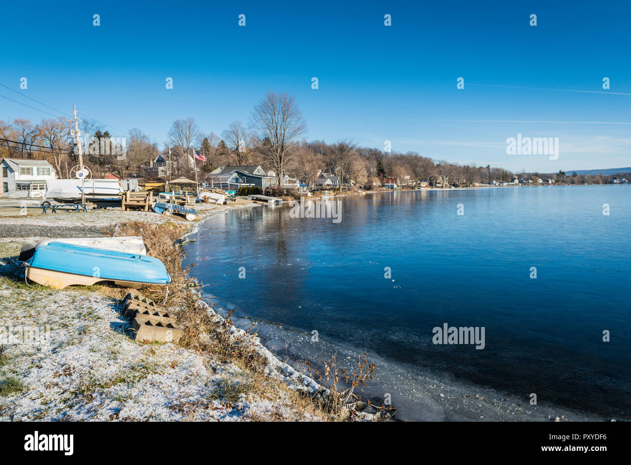 Snow covers shore by freezing water as boats are put up for the winter