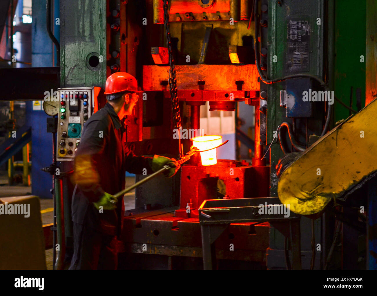 Hot iron in smeltery held by a worker. High precision hot