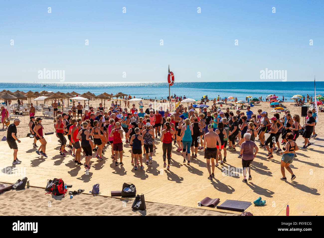 People exercising as a group on the public beach at Monte Gordo, Algarve, Portugal Stock Photo