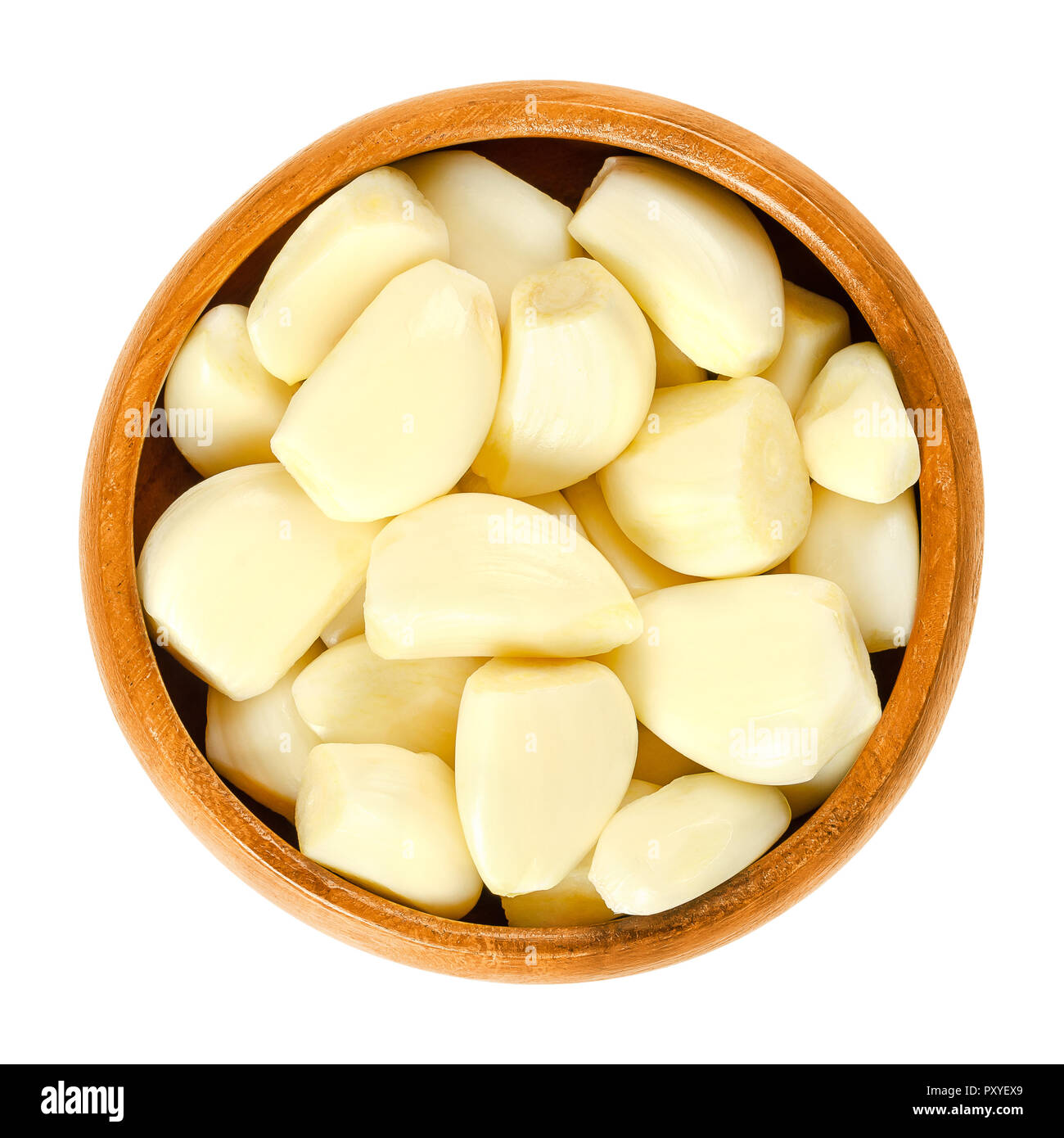 Peeled garlic cloves in wooden bowl. Allium sativum, with its pungent flavor is used as a seasoning or condiment and also in medicine. Stock Photo