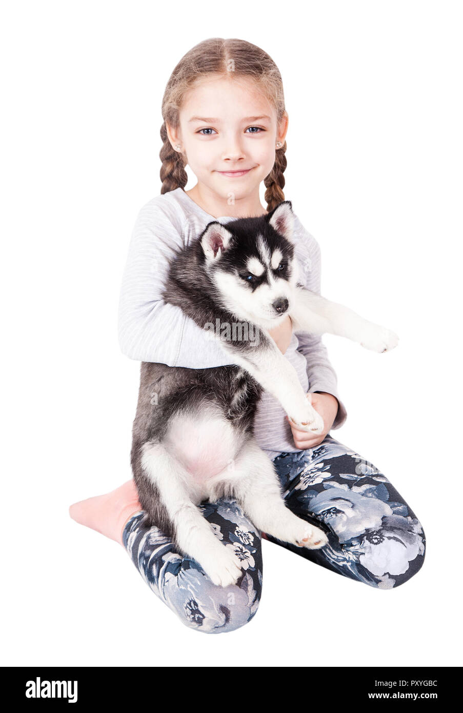 Cute little girl hugging a husky puppy, isolated on a white background