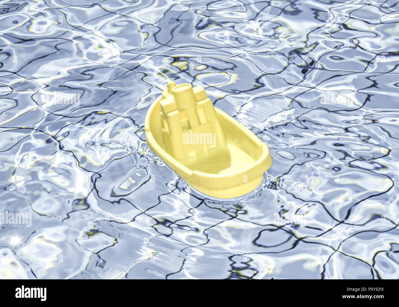 Gelbes Plastikschiffchen schwimmt in Pool Stock Photo