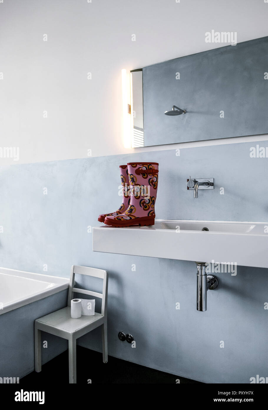 Badezimmer, Gummistiefel stehen auf Waschbecken Stock Photo