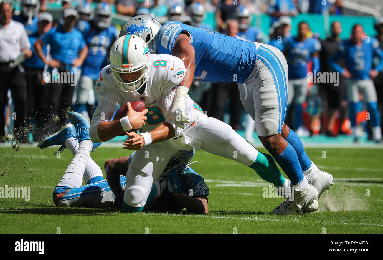 Miami Gardens, Florida, USA. 21st Oct, 2018. Miami Dolphins quarterback Brock Osweiler (8) is stopped by Detroit Lions cornerback Teez Tabor (31), bottom, and linebacker Devon Kennard (42), right, during a NFL football game between the Detroit Lions and the Miami Dolphins at the Hard Rock Stadium in Miami Gardens, Florida. Credit: Mario Houben/ZUMA Wire/Alamy Live News Stock Photo