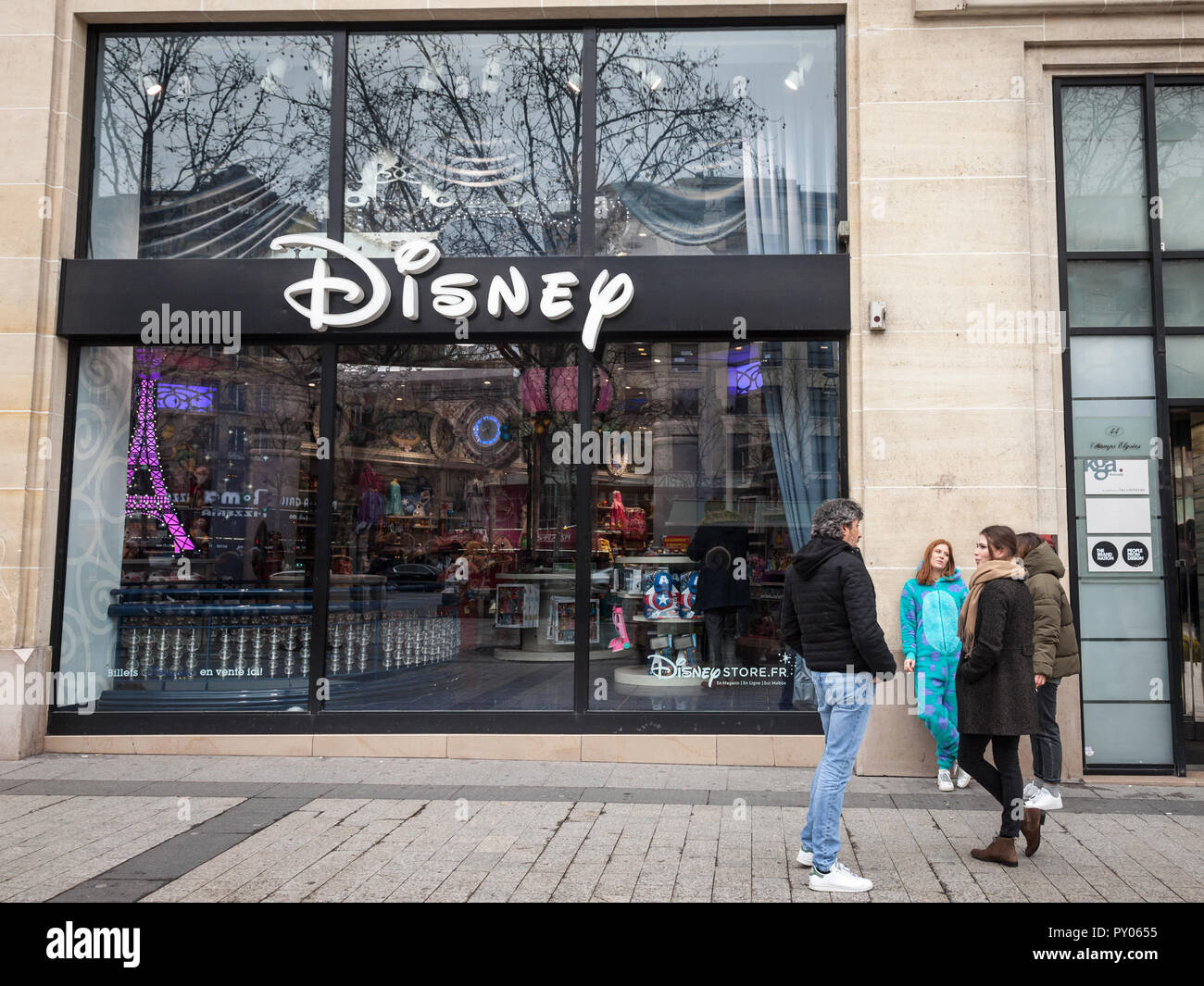 PARIS, FRANCE - DECEMBER 20, 2017: Costumed staff having a break in front of the Disney Store with its logo on Champs Elysees. Also known as shopDisne Stock Photo