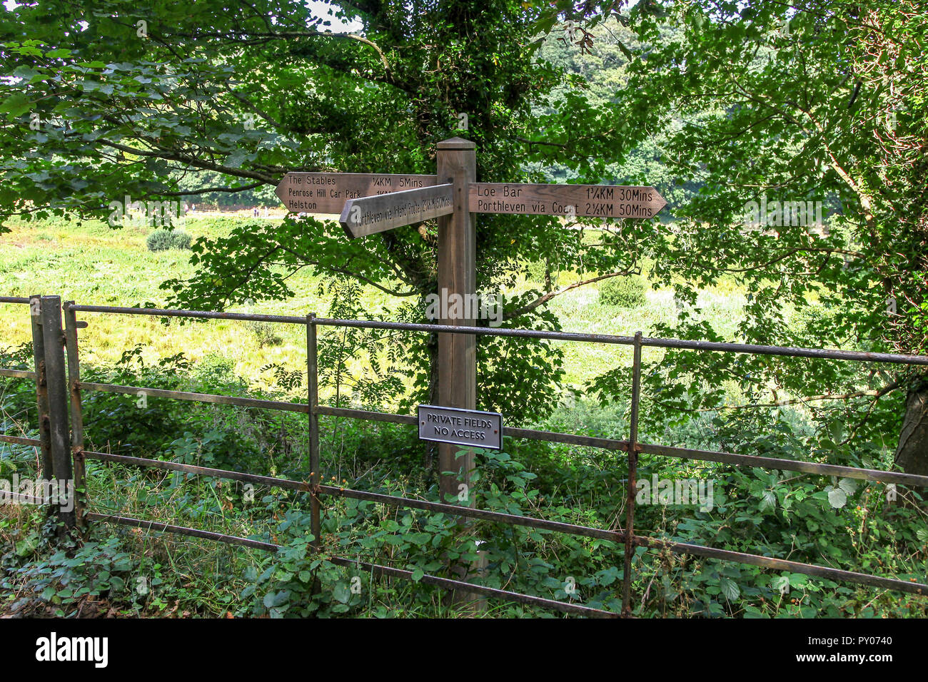 A wooden footpath sign post on the Penrose Estate near to Loe bar, near to Helston, Cornwall, England, UK Stock Photo