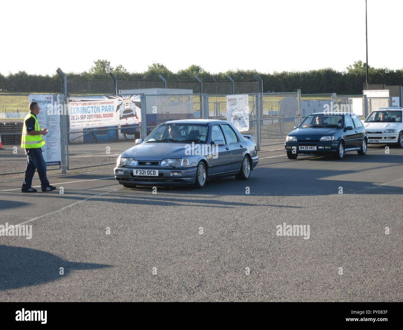 Ford RS sierra cosworth 4x4 and fiesta rs1800 shown at donnington park race circuit at the RS owners club national day - entering show ground with ticket marshall Stock Photo