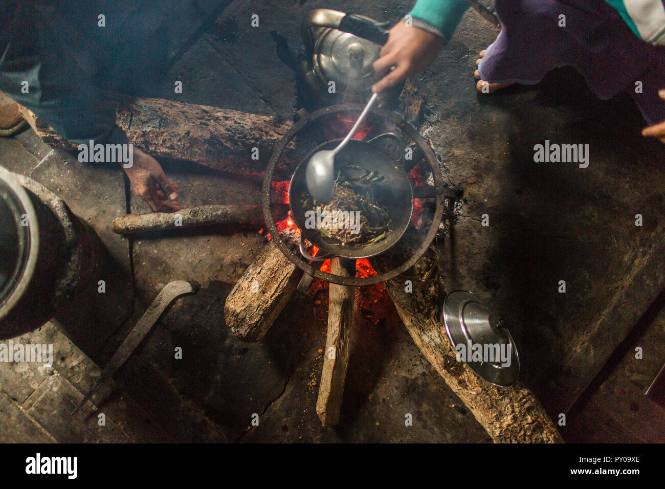 Directly above view of people cooking indoors over small campfire, Myanmar, Shan, Myanmar Stock Photo