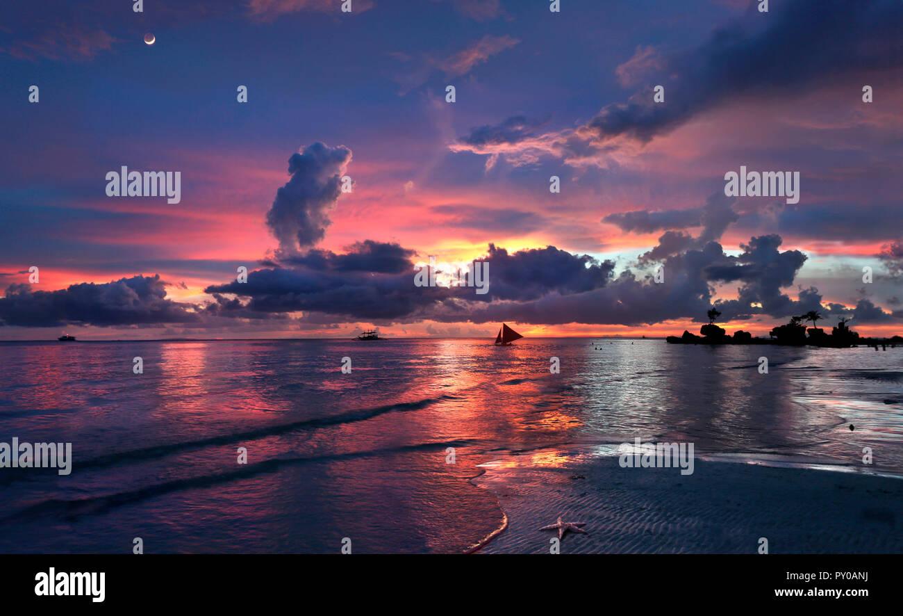 Tranquil scene with beach and sea at sunset with silhouettes of sailboats, Boracay, Aklan, Philippines Stock Photo