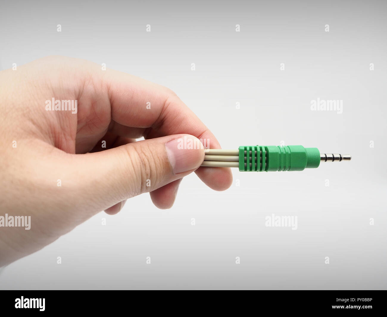 Hand holding a jack instrument cable on a white background. Stock Photo